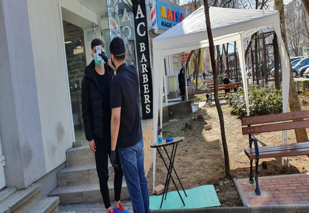 Cort pentru dezinfectarea clienţilor, montat la intrarea într-o frizerie din Slatina